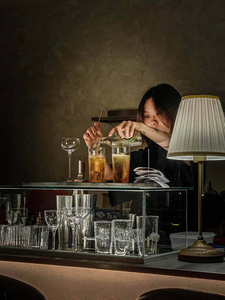 Skilled bartender creates refreshing cocktails at a café bar.
